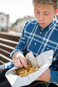 青少年男孩在外庭上吃法国薯条的情况社会四分之一图片