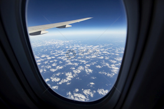 高度通过空气平面窗口对着蓝色天空的云层飞机航图片