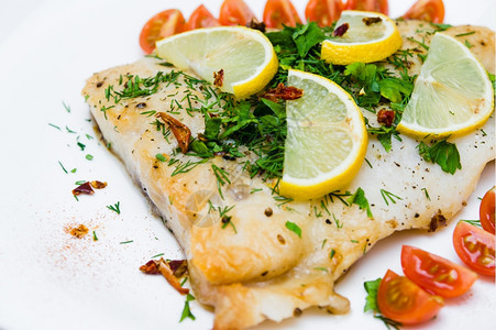 食物白盘上加蔬菜和奶油酱的烤鱼美食海图片