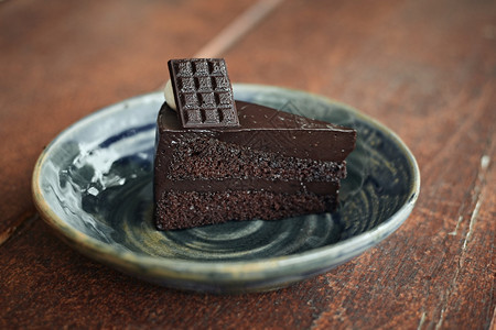 新鲜的海绵餐桌上有一块美味的自制巧克力蛋糕桌子上还有一块好吃的自制巧克力蛋糕可图片