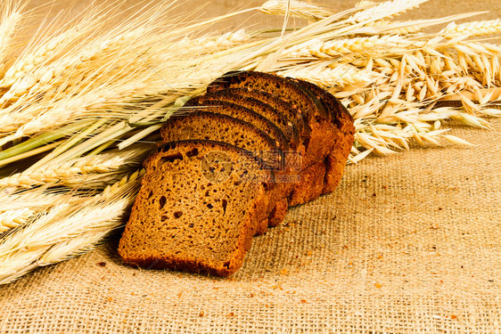 麻布背景的新鲜白面包黑麦的粮食图片