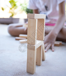 地面儿童在混凝土地板上玩木块建造有创力的图片