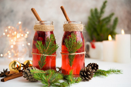 热的花环星两瓶传统节日杂音葡萄酒白桌上有浆果和香料还有圣诞花园和装饰品图片