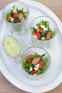 蔬菜晚餐用樱桃西红柿披风和茶叶在玻璃杯中的沙拉盘子图片