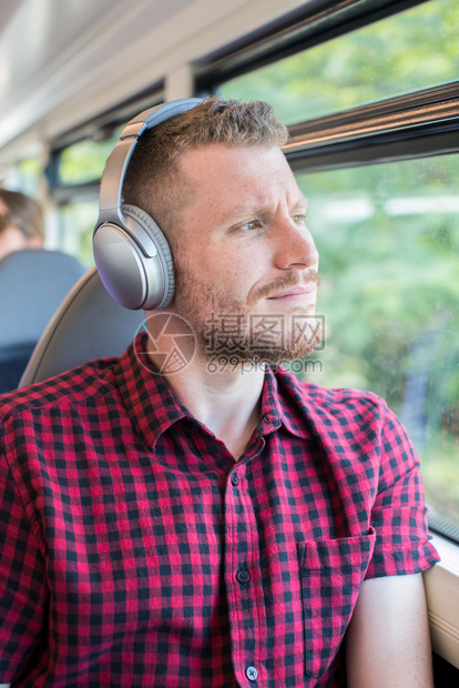 垂直的胡须通勤年轻人在上班途中听音乐时用耳机收听图片