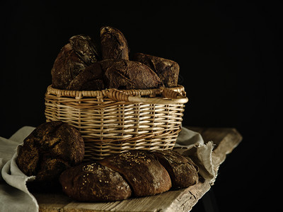 黑背景的篮子里自制黑麦面包棕色的小有机图片
