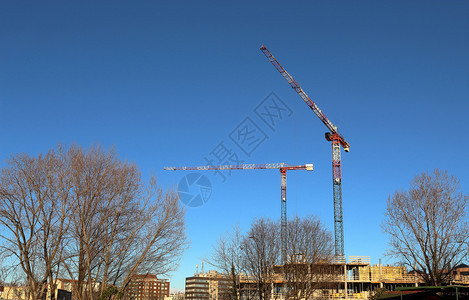 工程作住宅建筑未完工和起重机以清晰蓝天为背景图片