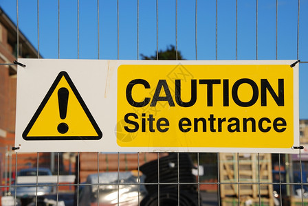 建造在筑工地的金属围栏上挂有警告工地入口标志象征黄色的图片