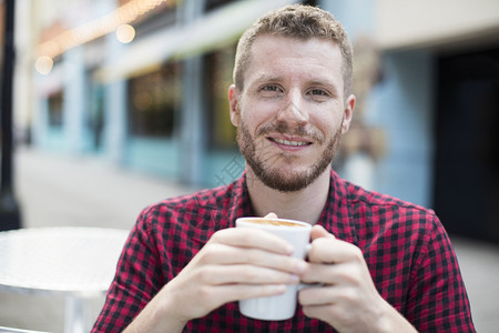 外厅咖啡的年轻人饮用咖啡的肖像轻松桌子男人图片