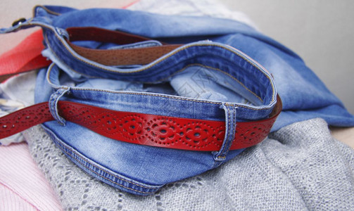 服装皮革腰带穿衣纺织品和红皮带的蓝色牛仔服布织物图片