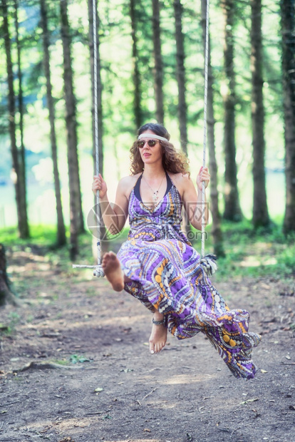 制作嬉皮风格的女孩挥舞在树林里摇摆微笑肖像图片