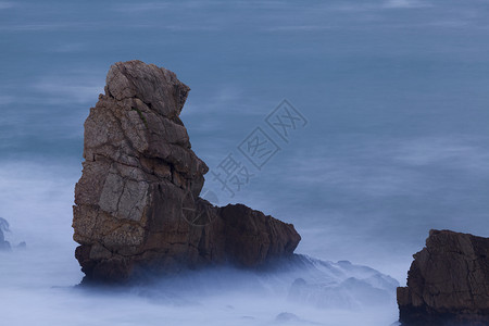 黄昏西班牙坎塔布里亚州连克斯阿尔尼亚海滩的岩石许可证结图片