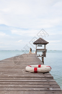 轮廓港口木桥上的橡胶环海中木质展厅后面的大桥上天空最晴朗旅游图片