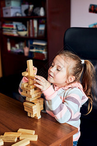 童年小女孩学龄前幼童玩木砖具建造一座塔构筑房子的概念一种乐趣图片