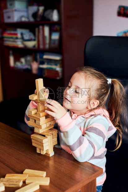 童年小女孩学龄前幼童玩木砖具建造一座塔构筑房子的概念一种乐趣图片