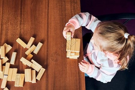 小女孩学龄前幼童玩木砖具建造一座塔构筑房子的概念教育喜悦木制的图片