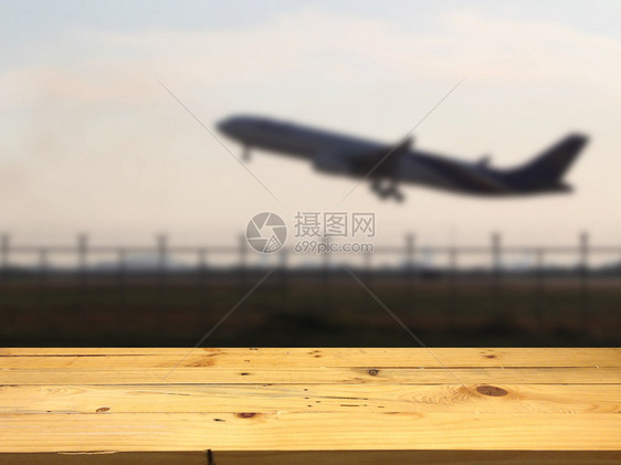 云木制的空桌间平台和模糊的飞机对产品显示相容的背景进行更新航班图片