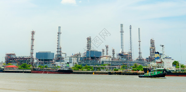工厂管道生产在全景河图象上反射的炼油厂图片