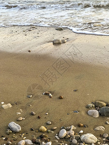 脚丫子走打印从海岸拉出波浪和石块图片