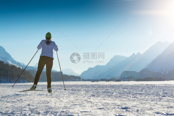 雪山上滑雪的年轻女性图片