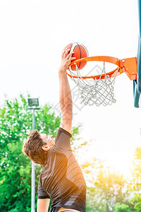 城市乐趣一名白人篮球运动员在市区公路户外田野表演的男图片