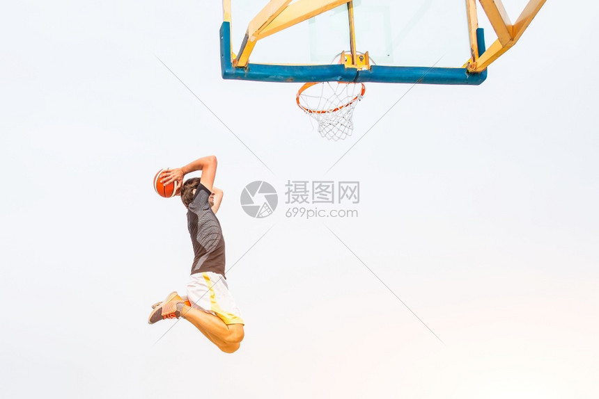 一名白人篮球运动员在市区公路户外田野表演的场地城市篮子图片