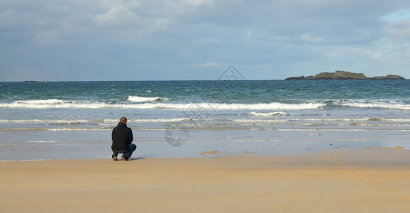 男人海浪波特拉什独自一个人在海滨上寻找远处图片
