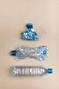 纸板背景上压扁的塑料瓶收集废物以回收污染和过多废物的概念顶部复制空间垃圾浪费概念的图片