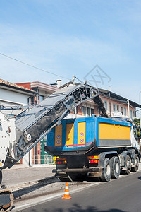 道路施工冷板机将沥青碾磨到垃圾车寒冷的铺路图片