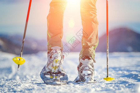 女孩人们远足山上带技术雪鞋步行的细图图片