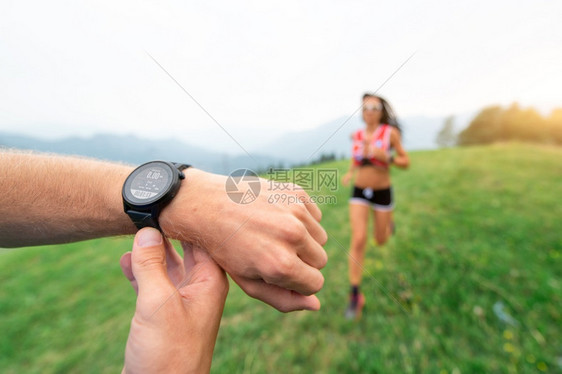 尽管运动训练教在自然运动的女孩时握住手表卡路里种族图片