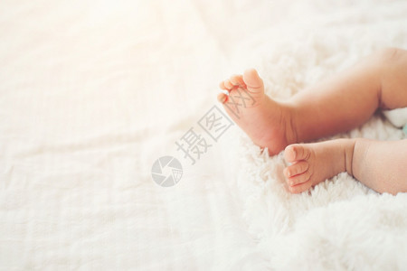 尿布白床上新生婴儿腿孩子柔软的图片