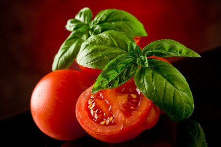 相片的新鲜切西红柿玻璃桌上有巴西尔和亮光食物草药营养图片