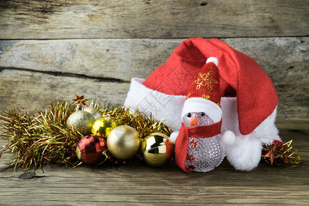 白色的帽子SantaHat圣诞礼服和旧木背景的圣诞装饰玩具娃图片