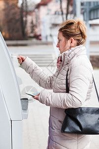 自动的银行画妇女从自动取款机中提钱财图片
