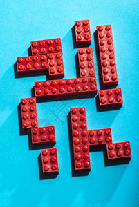 学习红塑料几何立方对比蓝底面的红塑料几何立方体在形状上建造玩具安装在行内排列的几何形状上在塑料砖布设的丰富多彩块图片
