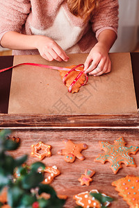 手工制作的曲奇饼桌子女孩捆绑的烤圣诞面包饼干和丝带图片
