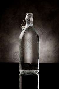 柜台黑色玻璃桌上的冷水瓶和反光相片凉爽的缩合图片