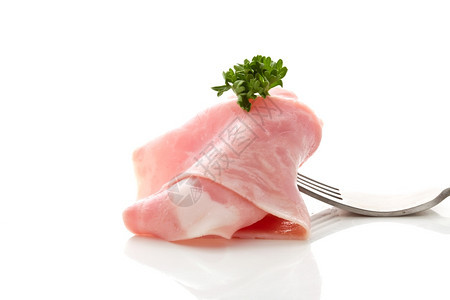 照片美味的火腿切片用叉子包在白色背景上香菜美食包裹图片
