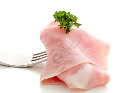 照片美味的火腿切片用叉子包在白色背景上投标草本植物饮食图片