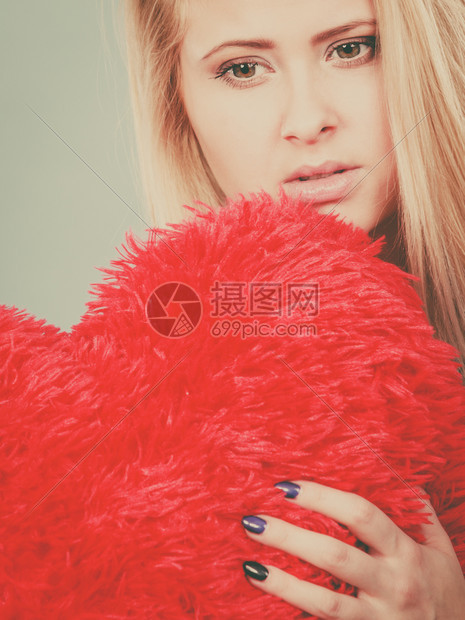 失望浪漫的伤害分手离婚坏关系概念萨德压抑的女士拿着大红发毛绒枕头在心脏形状她需要爱悲伤的女士抱着红枕头在心脏形状图片