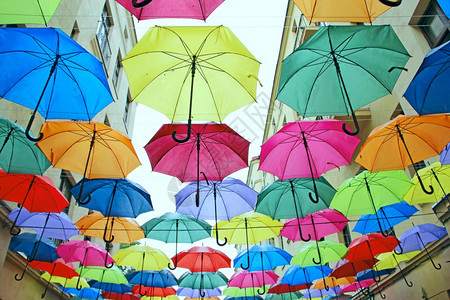 悬挂在顶层各不同伞的一组顶部彩色雨伞挂在顶层地方标志上的彩色雨伞不同颜绿图片
