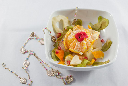 成熟白色背景的水果沙拉碗和项链复合面团装饰品白色的新鲜图片