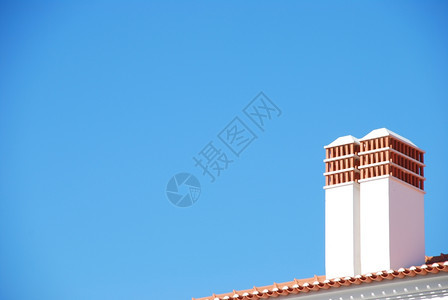 公寓蓝色天空背景的两座传统烟囱细节屋顶图片