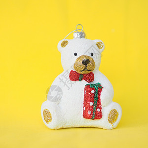 一种快乐的圣诞树玩具可爱的白色泰迪熊黄背景的图片