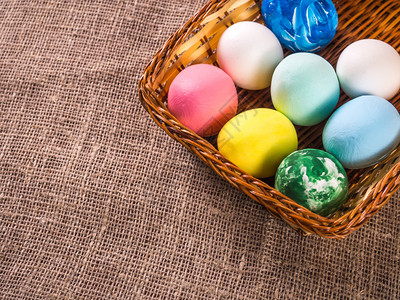 温和的柳条粉色复活节鸡蛋在一个篮子里布料背景上图片
