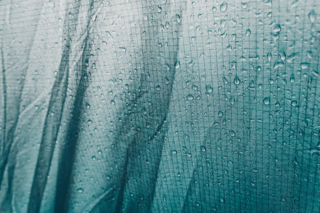 以水滴为背景的绿色织物帐篷雨上的水滴保护避雨材料自然庇护所图片
