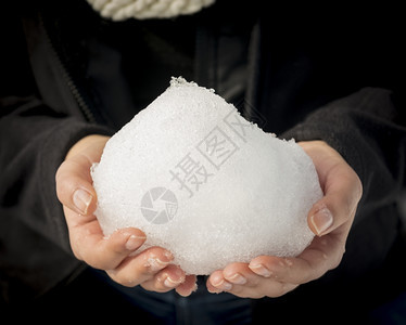 白色的季节女人赤手空拳地用浅的焦点握着巨大的雪球重点图片