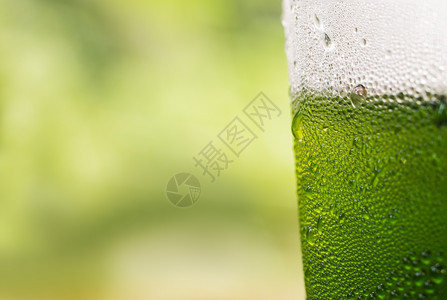 有绿色背景的塑料饮瓶上滴水的以绿色背景为稻草颜色抽象的图片
