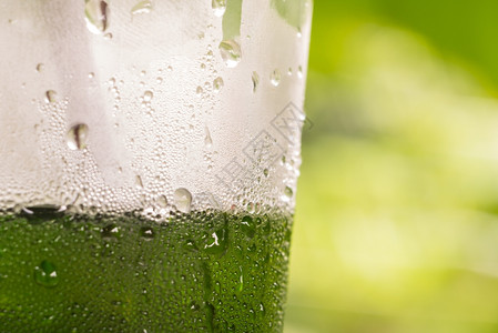 气泡流动有绿色背景的塑料饮瓶上滴水的以绿色背景为溅图片